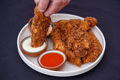 Chicken Tenders near Collingswood dipped into sauce.